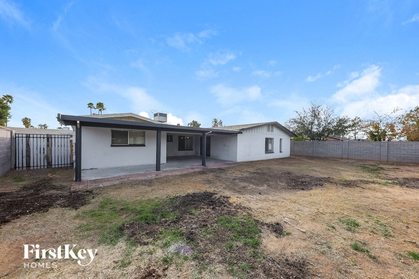 a small white house with a yard and a fence