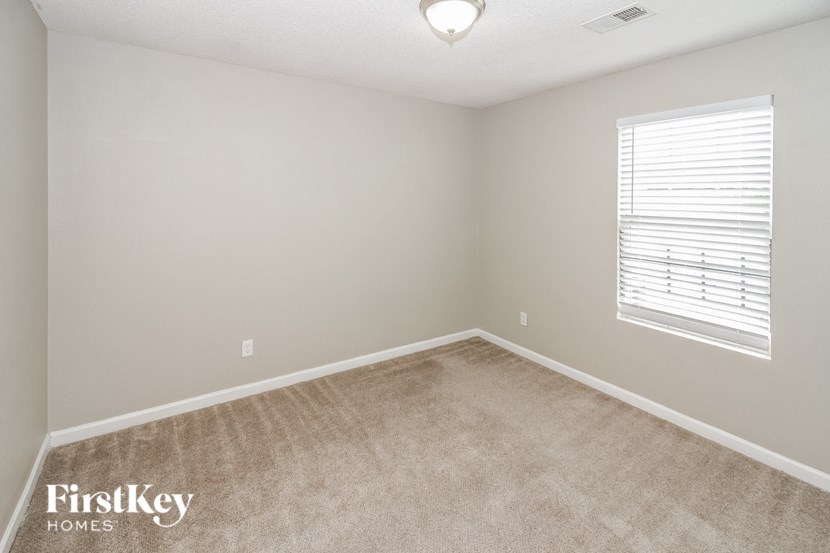 a bedroom with a carpeted floor and a window