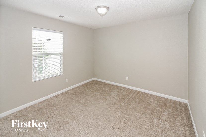 a bedroom with a carpeted floor and a window