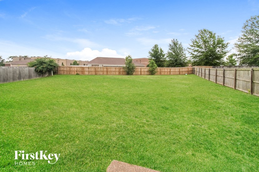 a fisheye view of a fenced in backyard with a grass lawn