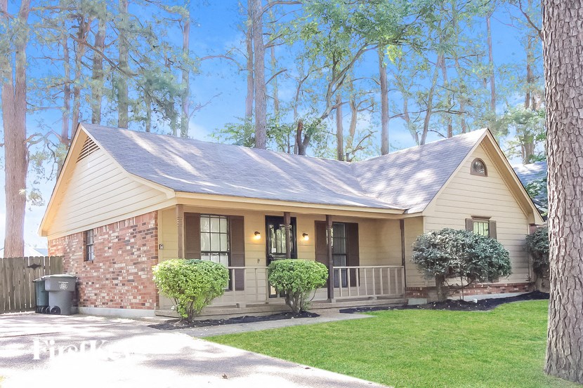 A house with a brown roof and a porch.
