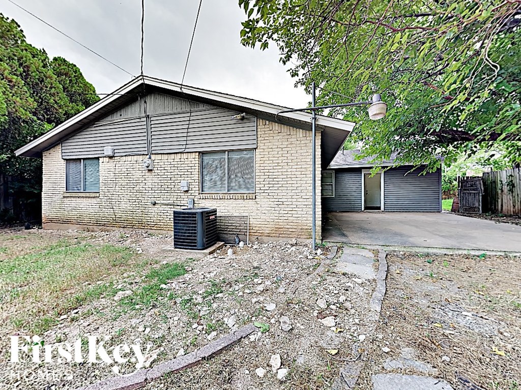a brick house with a trash can in front of it