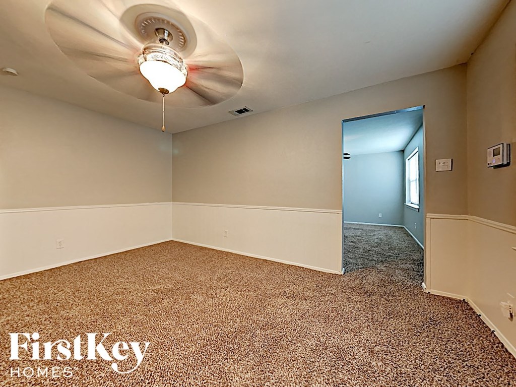 the living room of an empty house with a ceiling fan