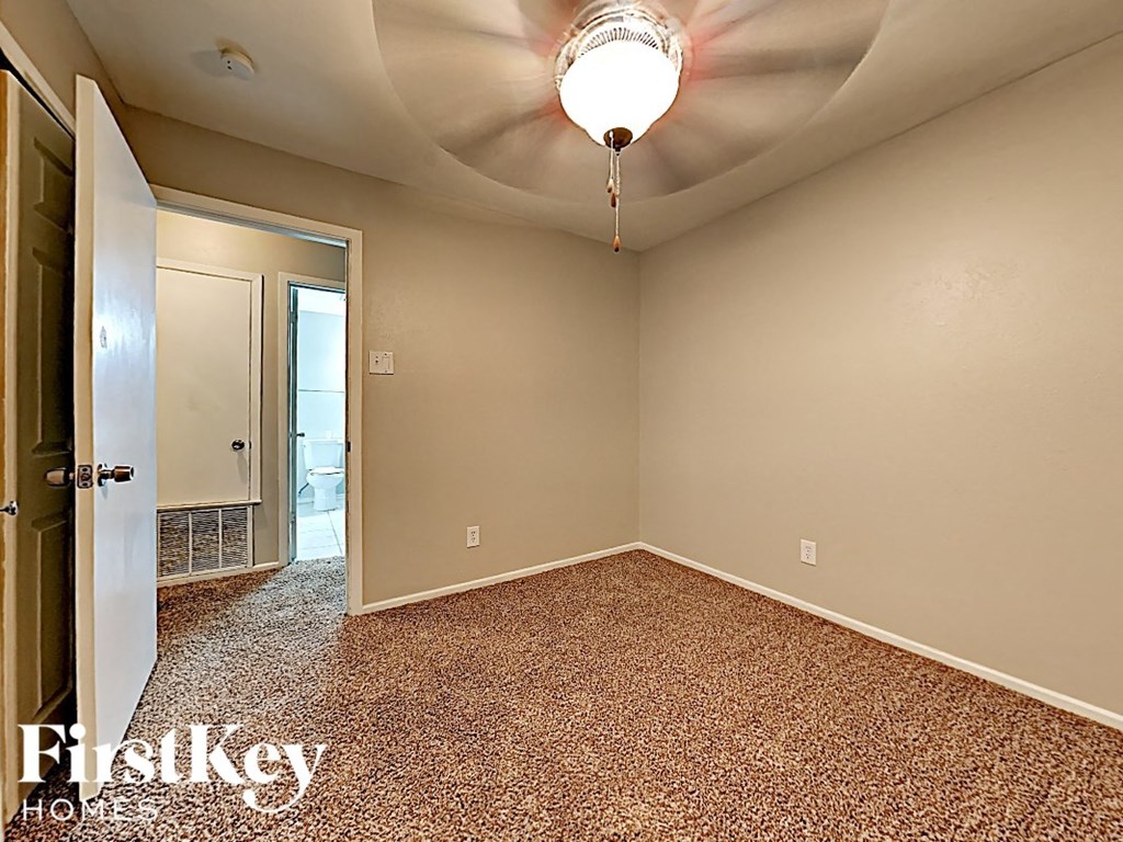 the living room of an empty house with a ceiling fan