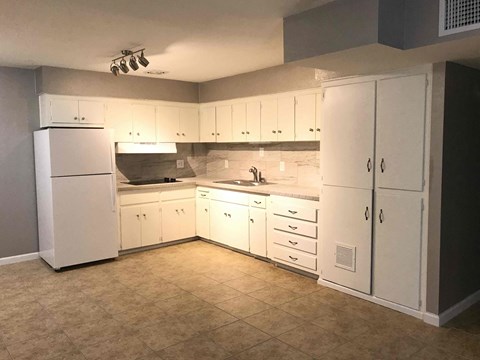 A kitchen with white cabinets and appliances.