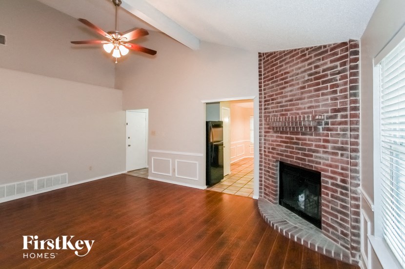 the living room of an empty house with a brick fireplace