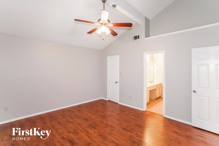 a living room with wood floors and a ceiling fan