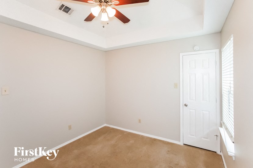 a bedroom with a ceiling fan and a white door