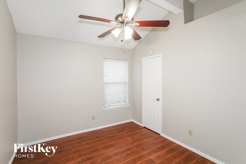 a bedroom with a ceiling fan and a door
