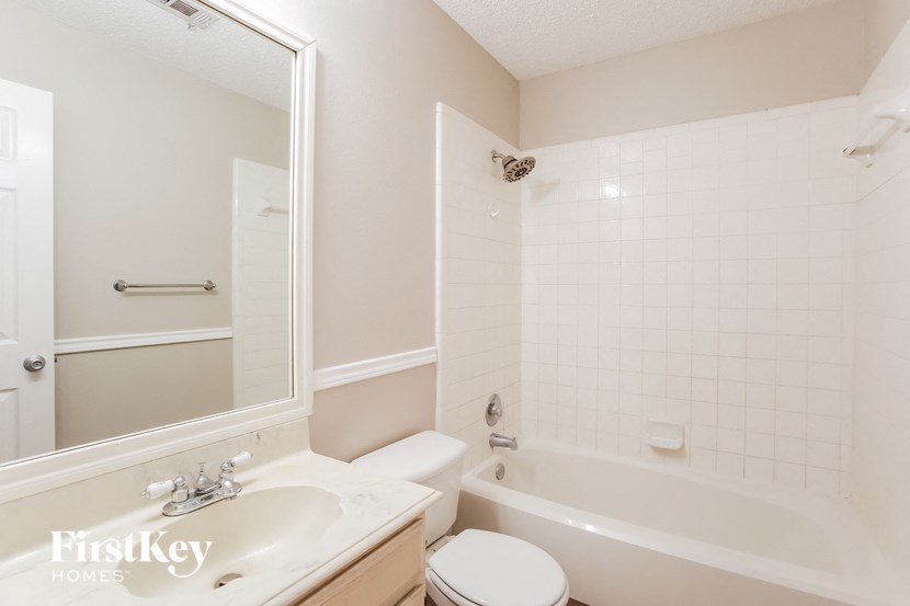 a white bathroom with a tub and a sink and a toilet