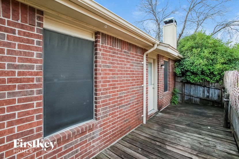 a brick exterior of a house with a wooden deck