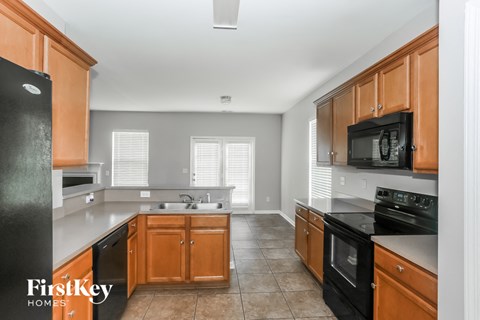 A kitchen with wooden cabinets and black appliances.