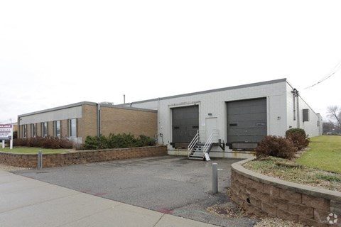 a building with two garage doors and a sidewalk