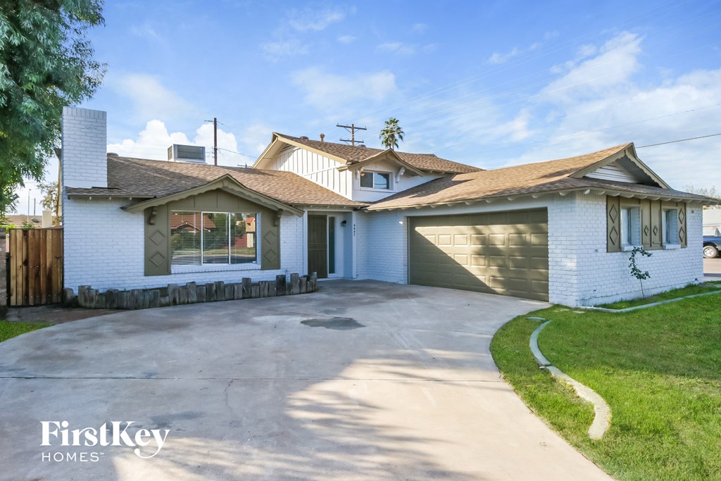 a white brick house with a driveway and a garage door