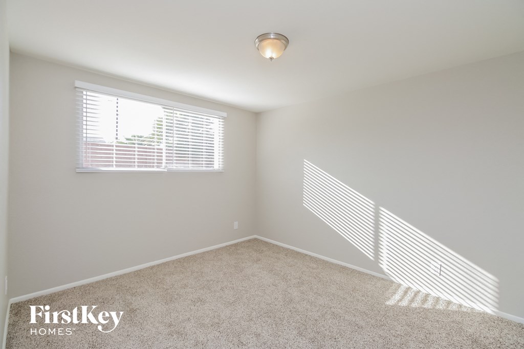 a bedroom with a carpeted floor and a window