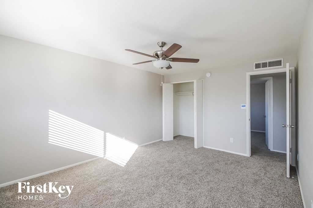 a bedroom with white carpet and a ceiling fan