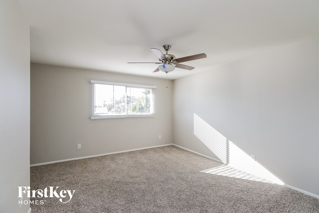 a bedroom with a ceiling fan and a window