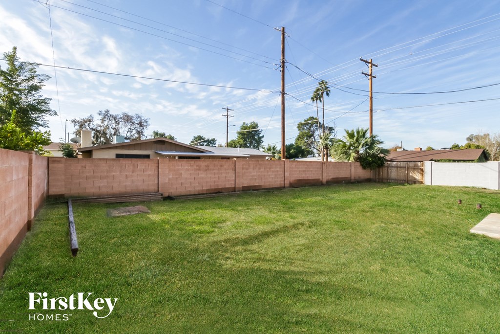 the backyard of a house with a fence and grass