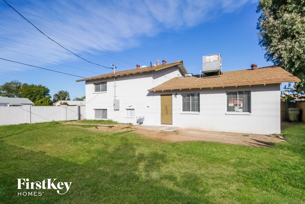 a white house with a brown roof and a yard