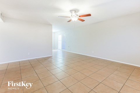 A spacious room with a ceiling fan and tiled floor.