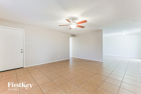 A room with a ceiling fan and tile flooring.