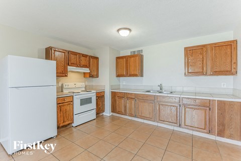 A kitchen with wooden cabinets and a white refrigerator.