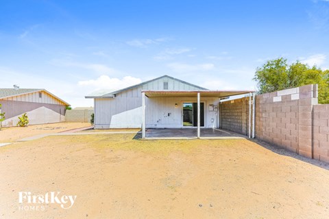 A house with a white exterior and a brown fence is for sale.