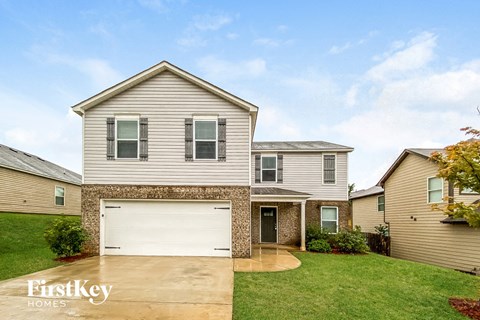 a house with a white garage door in front of a yard