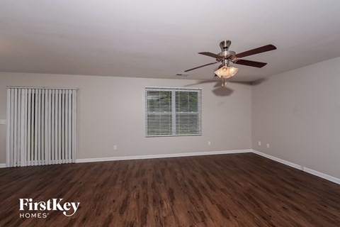 the living room of an empty house with a ceiling fan