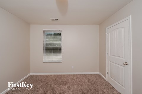 a bedroom with a carpeted floor and a white door