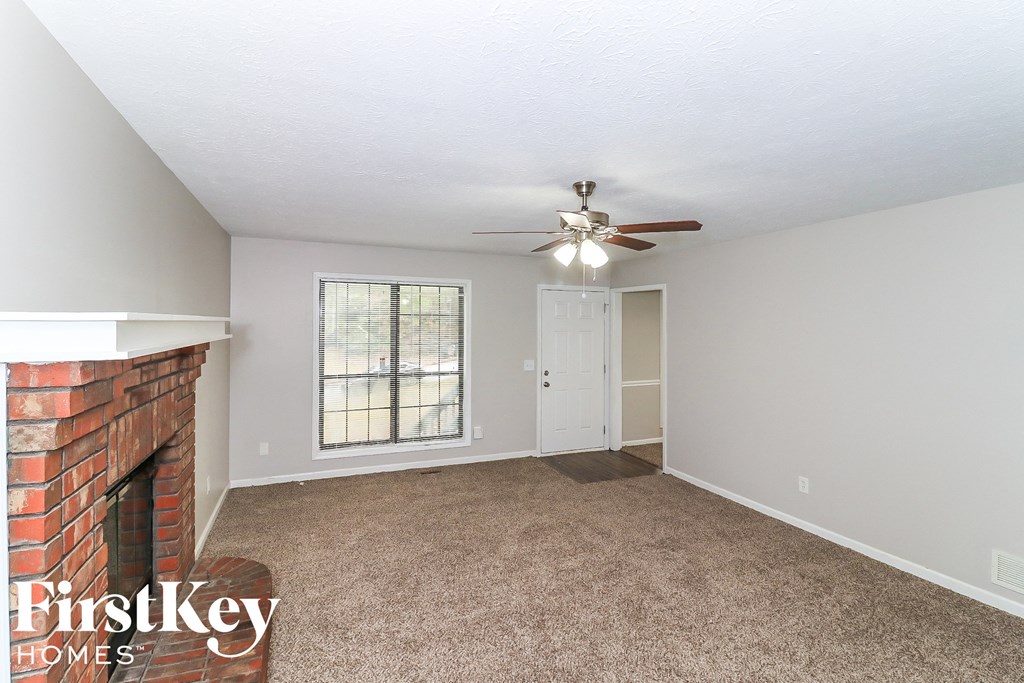 A room with a fireplace and a ceiling fan.