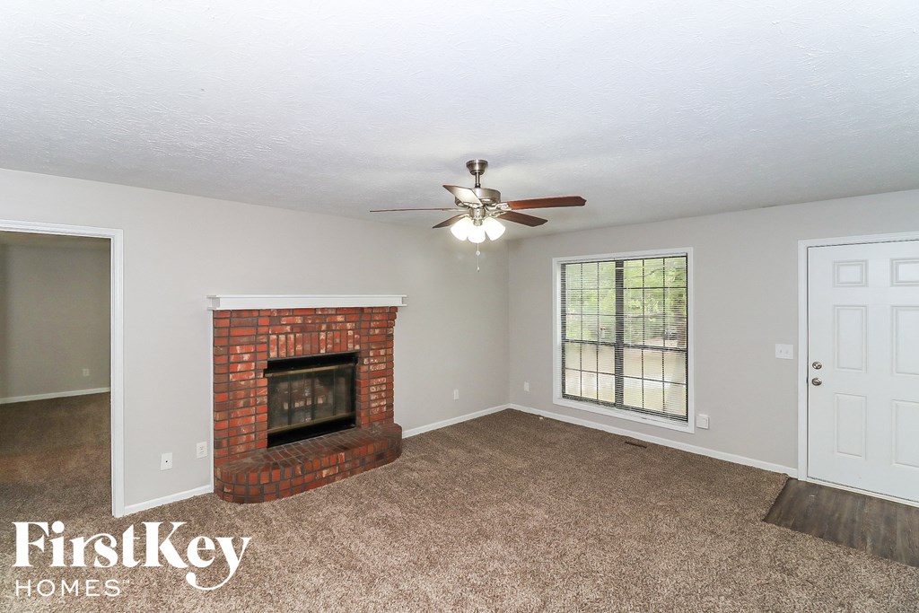 A room with a fireplace and a ceiling fan.