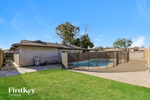 a backyard with a pool and a fence and a house
