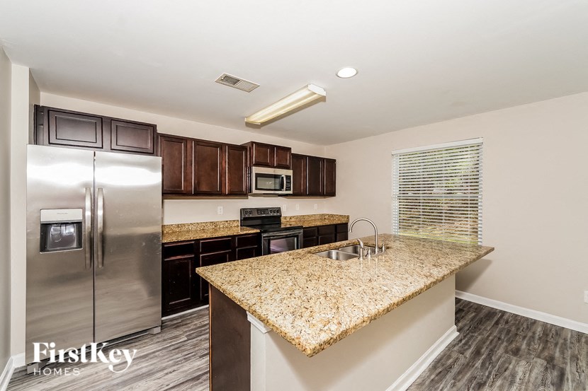A kitchen with a granite countertop and stainless steel appliances.
