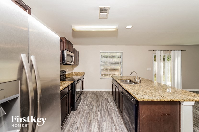 A kitchen with a granite countertop and stainless steel appliances.