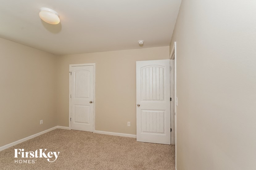 A room with two doors and a carpeted floor.
