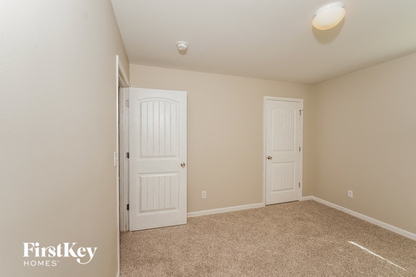 A room with two doors and a carpeted floor.