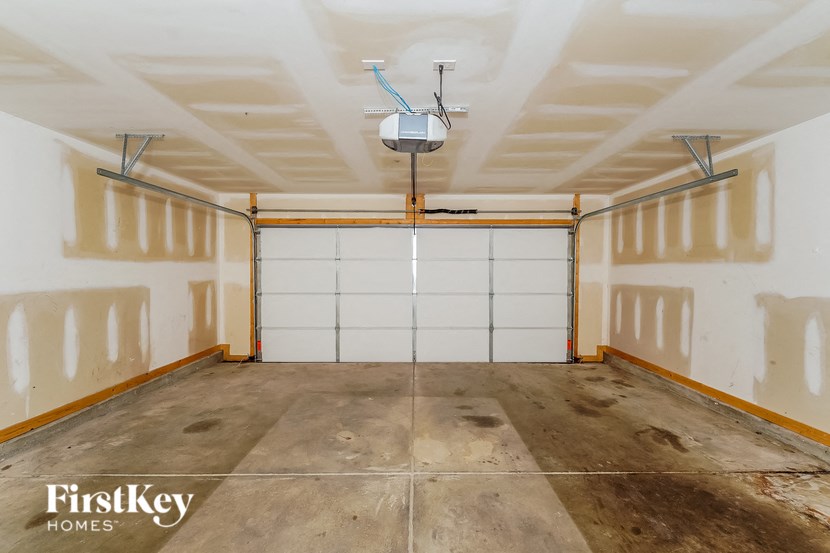 A garage with a white ceiling and a white door in the middle.