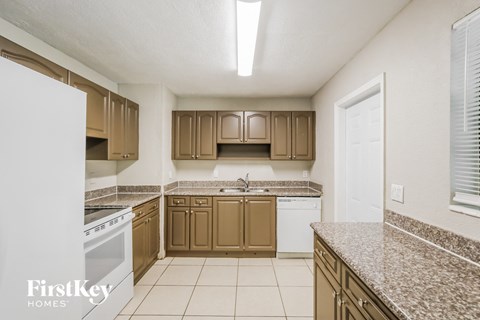 a kitchen with granite counter tops and wooden cabinets