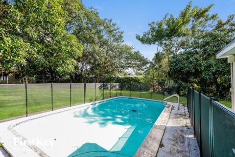 a swimming pool in a backyard next to a fence