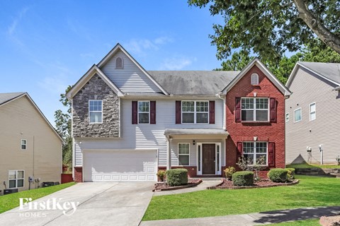 A house with a stone wall on the front.