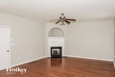 A room with a fireplace and a ceiling fan.