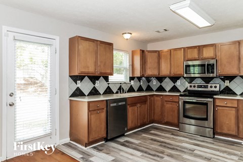 A kitchen with wooden cabinets and a black dishwasher.