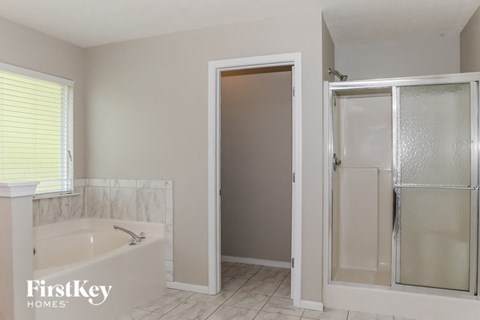 A white bathroom with a tub and a shower.