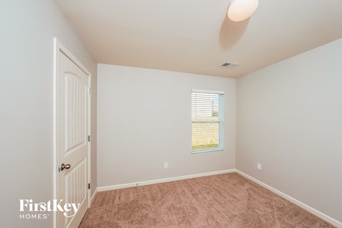 a bedroom with carpet and a door to a closet