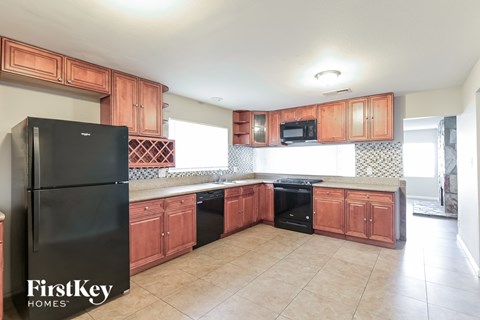 A kitchen with wooden cabinets and black appliances.
