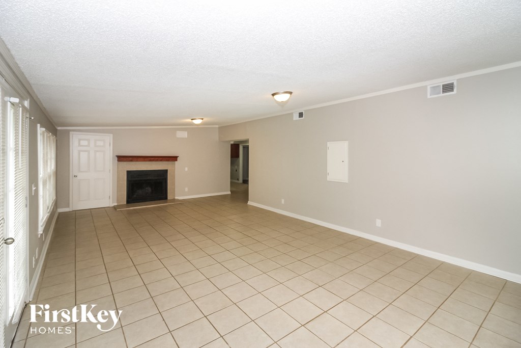 a living room with a fireplace and a tiled floor