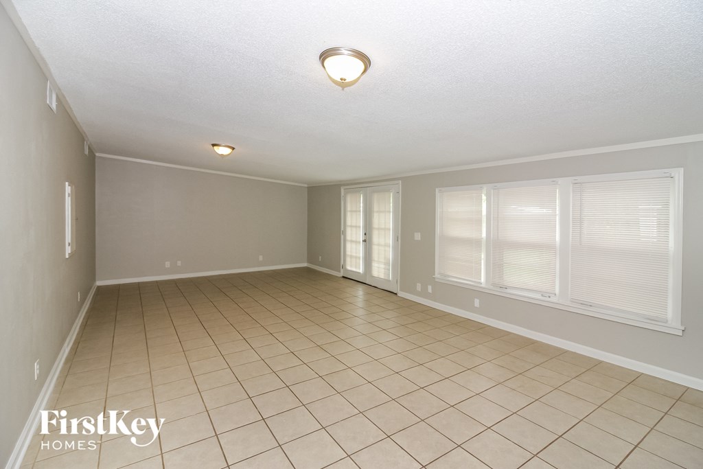 a spacious dining room with tiled flooring and large windows