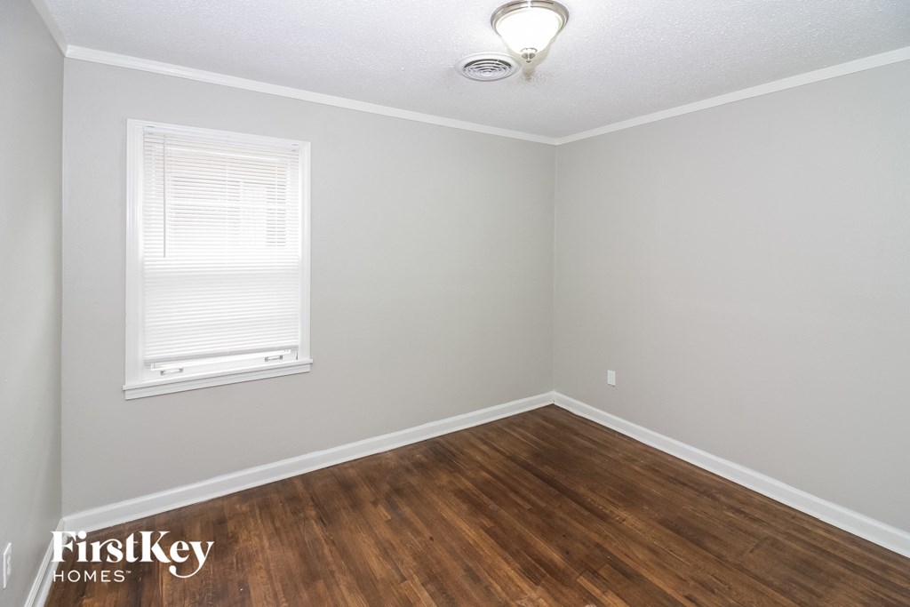 the living room of a house with wooden floors and a window