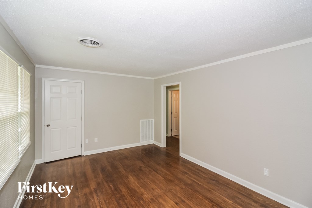 a living room with wood floors and a white door